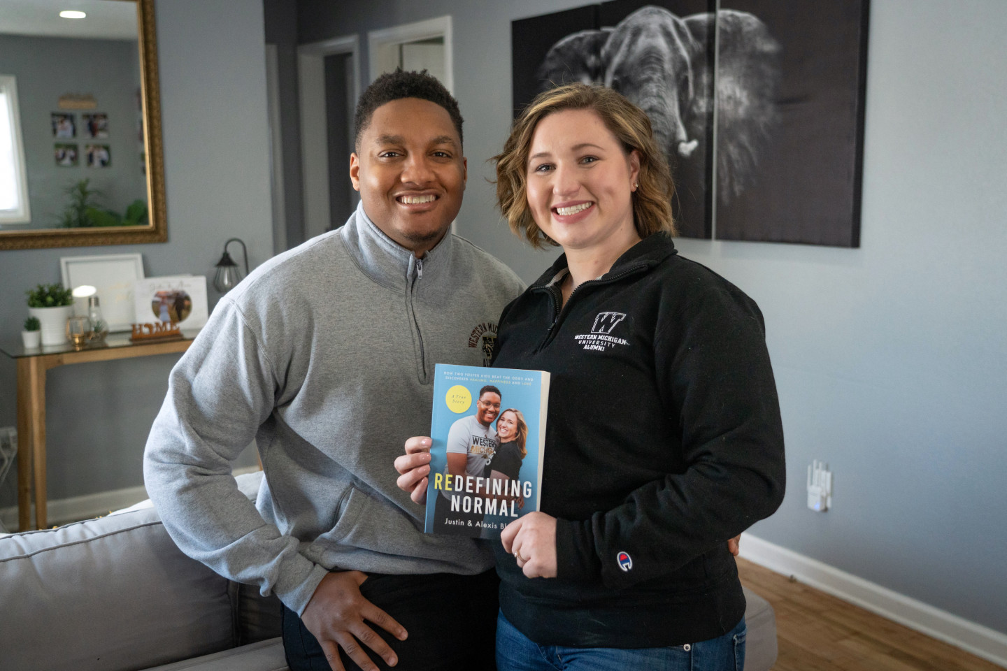 Justin and Alexis Black pose in their home with their book, "Redefining Normal."