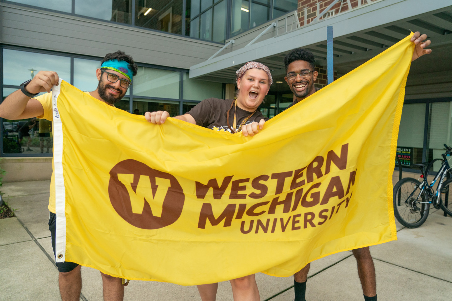 Three students hold up a western flag.