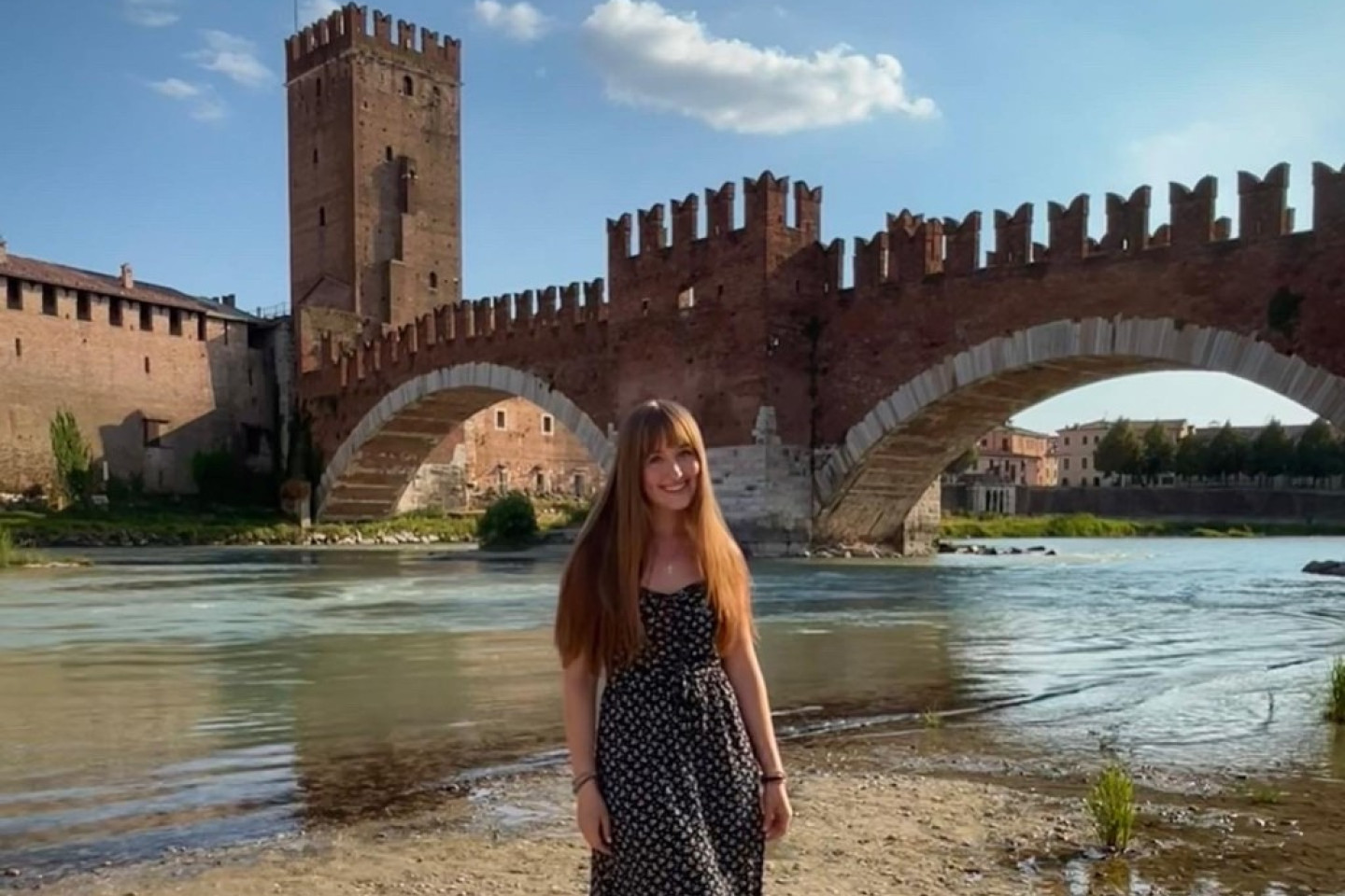 Emma Simpson stands in front of a body of water and bridge.