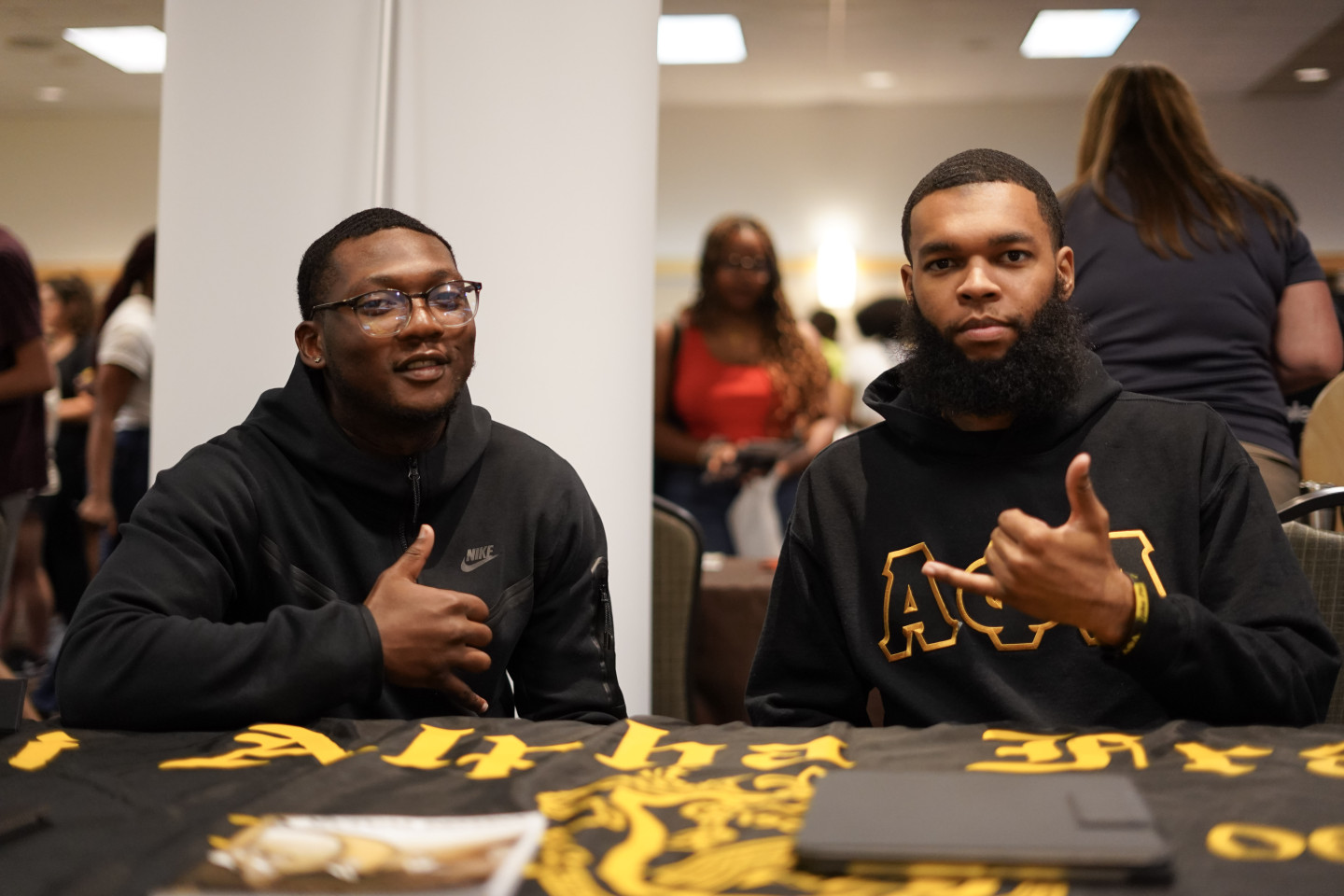 Two brothers of Alpha Phi Alpha sit at a table during an event at Western.