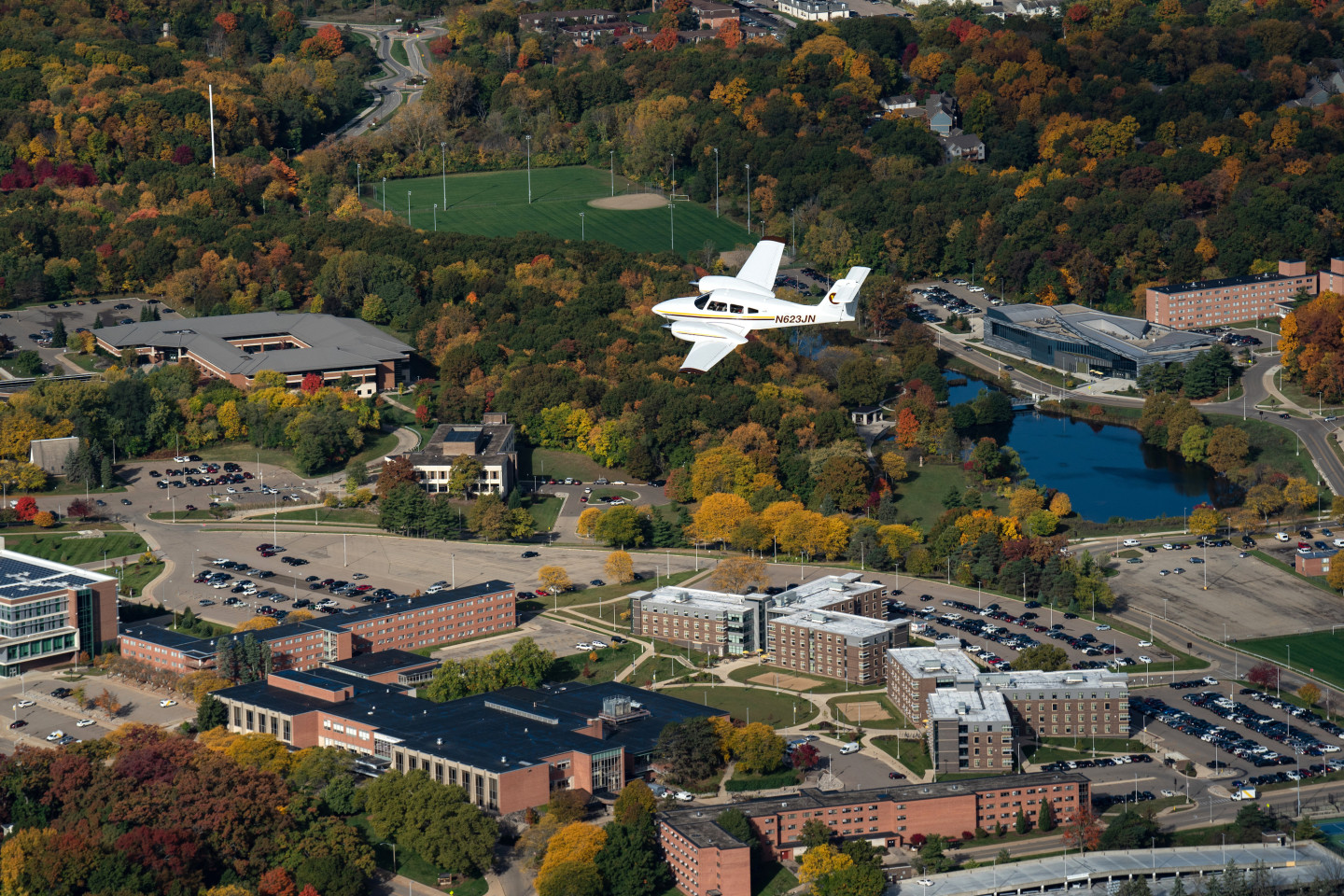 A small airplane flying in the sky over Western's campus.