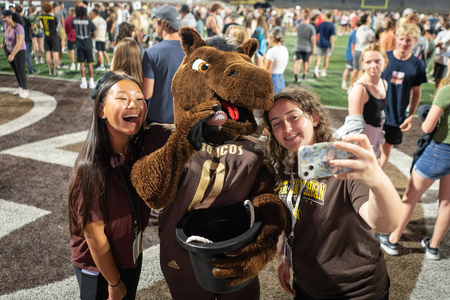Student fans share a selfie with Buster Bronco.