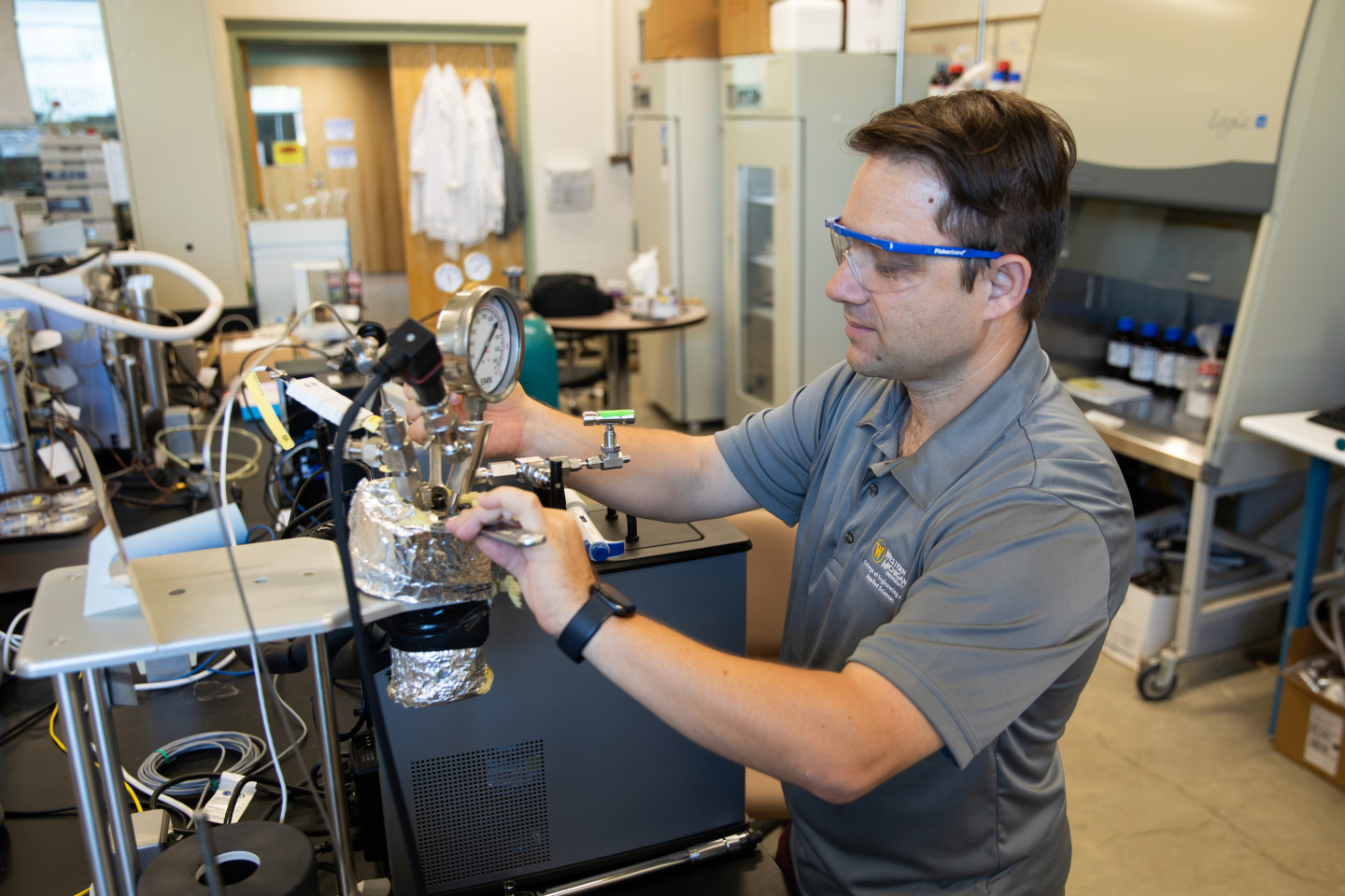 Mert Atilhan works with scientific equipment in his lab.