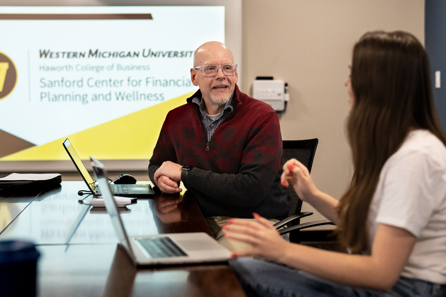 Todd Mora, seated at a table with a student in the Sanford Center for Financial Planning and Wellness