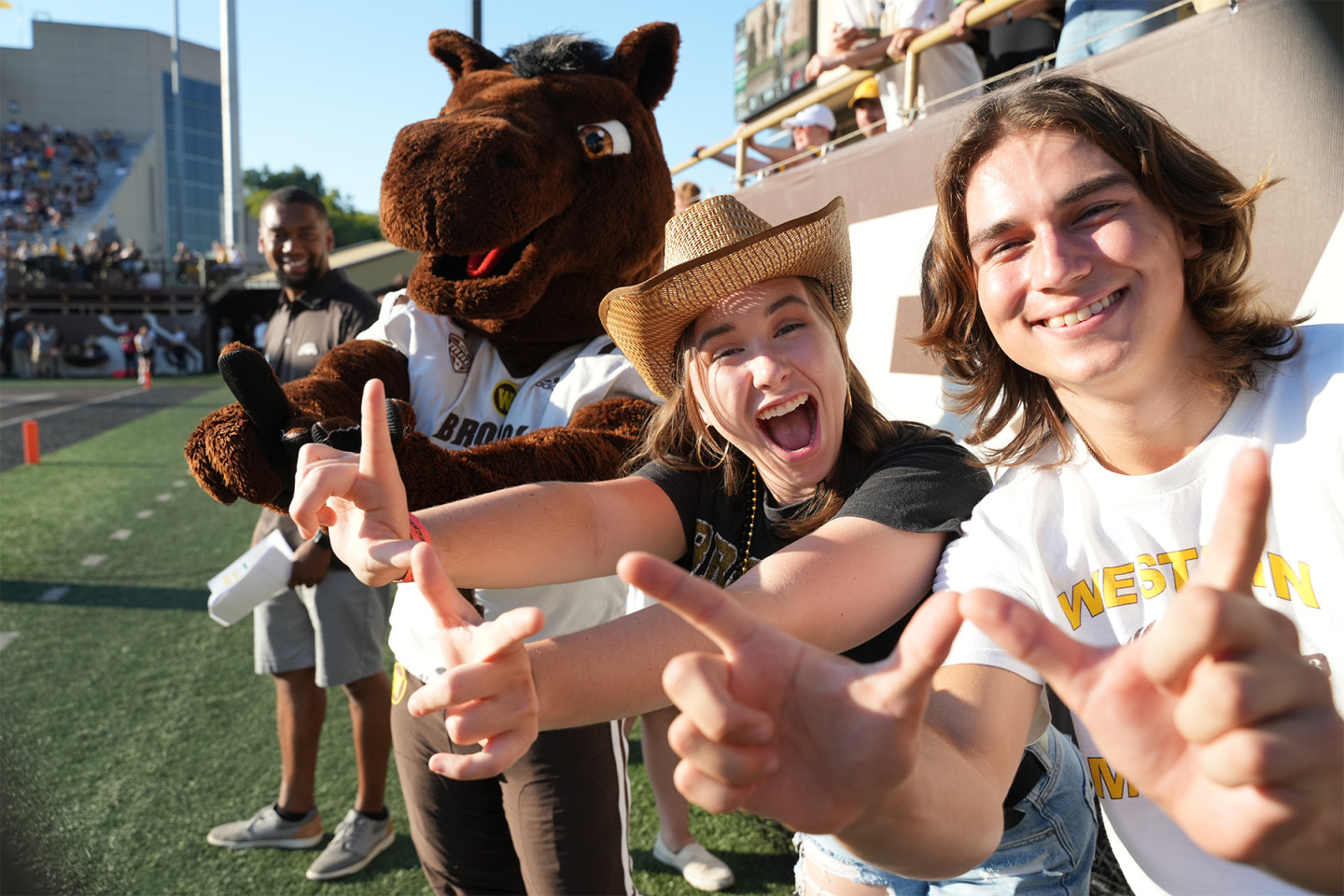 Fans celebrate on the field with Buster Bronco