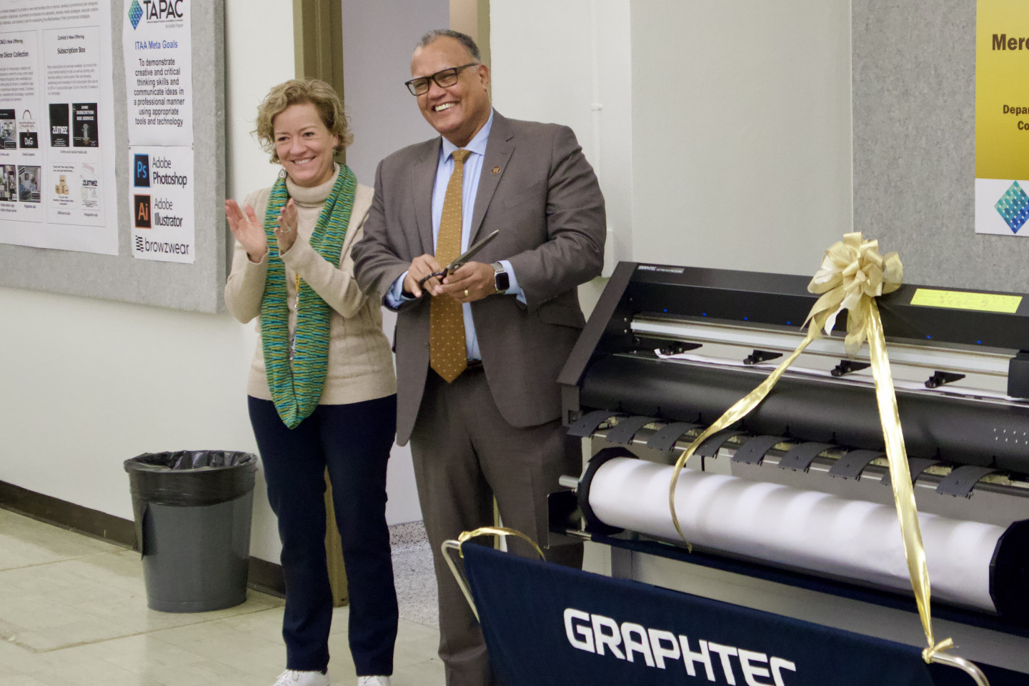 Dr. Laura Dinehart and President Edward Montgomery cut the ribbon for the new pattern plotter printer.