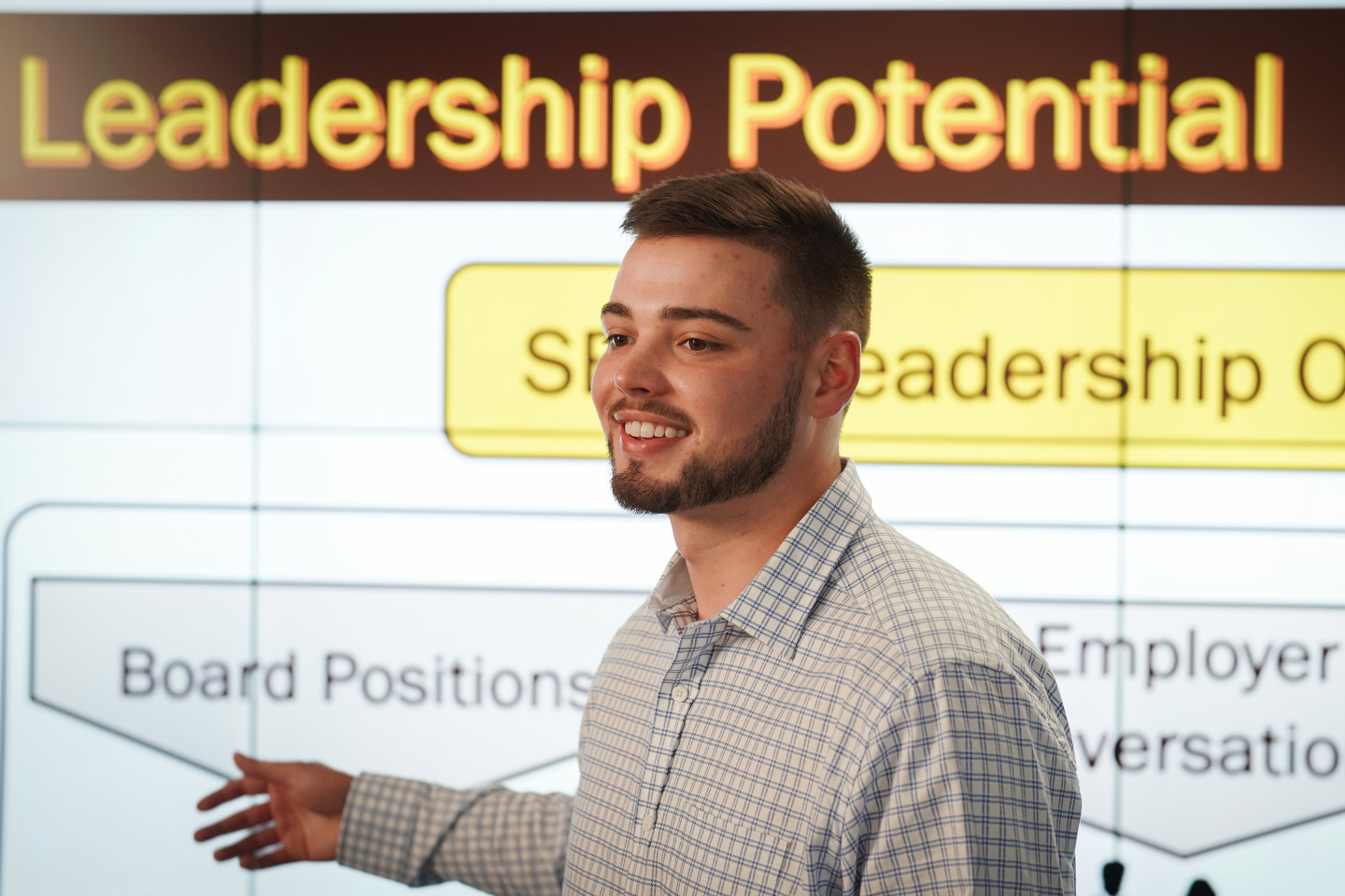A student stands infront of a display that reads Leadership Potential