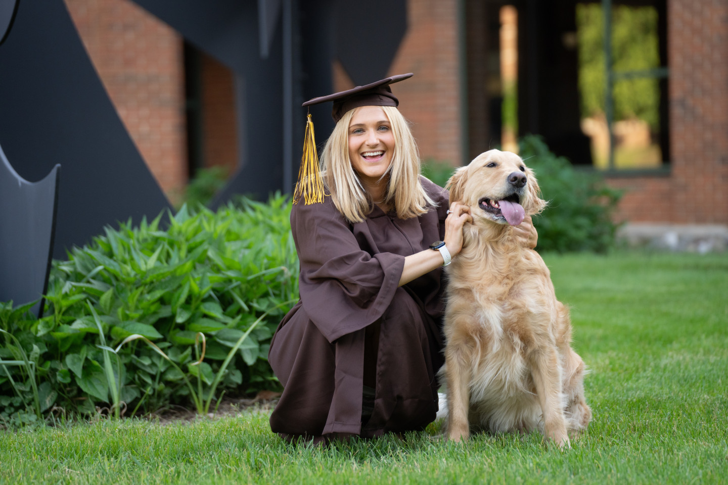 Taylor Ernst kneels down next to her dog.