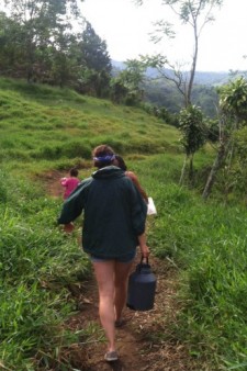 WMU student carries a heavy jug down a trail.