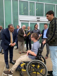President Edward Montgomery speaks with student Travis Waker, who is seated in his wheelchair.