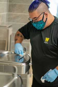 A custodian cleans a water fountain.