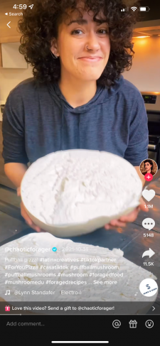 A screenshot from a video of Gabrielle  holding a large puffball mushroom that has been cut in half.