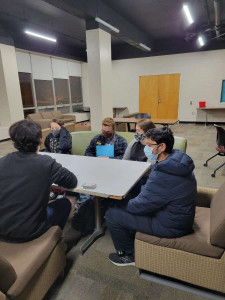Students sit around a table.
