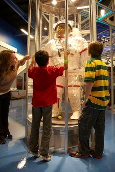 Photo of children looking at a spacesuit exhibit.