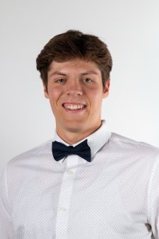 Headshot of Luke Thelen in a white shirt and black bowtie on a white background