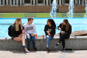 Students sitting by the fountain with snacks