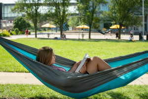 Student in hammock on campus during summer