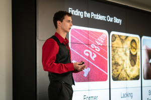 Business student at the front of a classroom, presenting.
