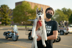 A student holds a husky puppy.