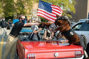 Buster Bronco bumps fists with a person during the parade.