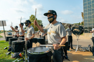 Bronco Marching Band members play the drums.