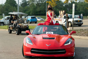 A member of the Homecoming Court rides in a convertible.