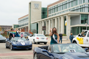 Members of the Homecoming Court ride in convertibles by Sangren Hall.