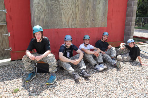 A group of campers rests after completing a scenario on the leadership reaction course.