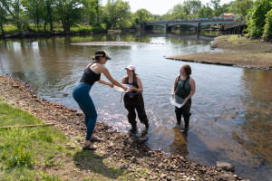 Students stand in the Kalamazoo River.