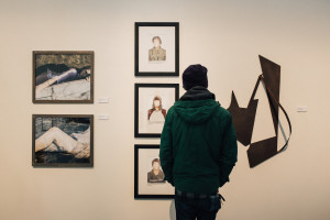 A person looks at pictures on a wall.