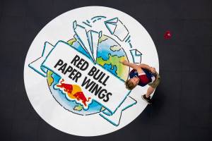 An aerial photo of Evin Cooper throwing a red paper airplane while standing on the 