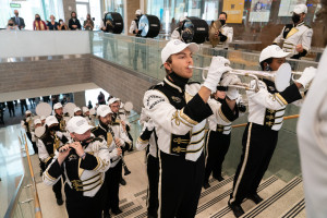 Bronco Marching Band members play on the steps inside of Sangren Hall.