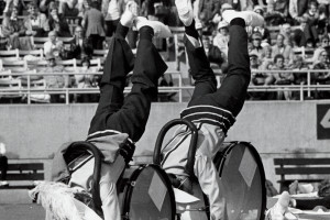 Marching band members do hand stands.