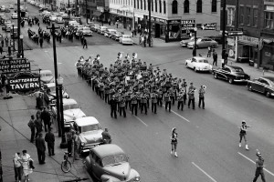 A marching band marches down a city street.