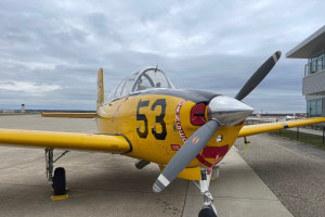 A small yellow plane sits on a runway.