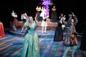 Actors sing and dance on stage during a musical.
