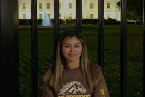 Joana Zuniga poses for a photo outside of the White House at night.