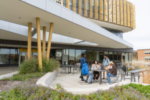 Students sit at a table on a patio outside of the WMU Student Center.