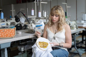 Laura Argentati sews beads onto a garment.