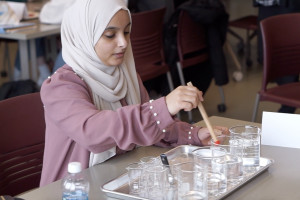 Student playing water xylophone.