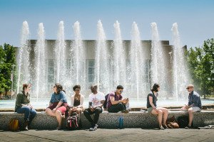 Students sitting in front of fountain