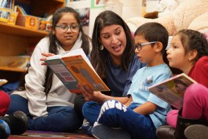 Zenia Gutierrez reads a book to children.