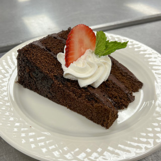 Chocolate cake with whip cream and strawberries