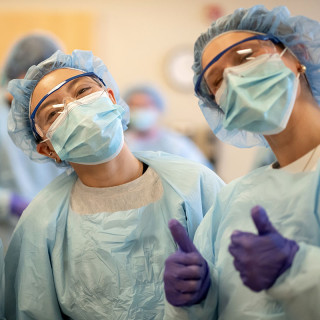 smiling students in nursing gear and gloves