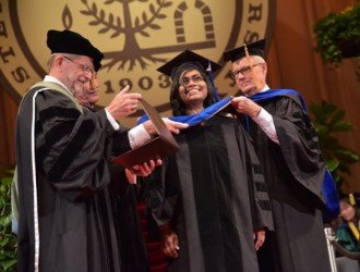 Graduate student receiving her diploma on stage