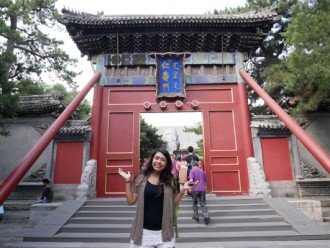 A female WMU student stands in front of a tomb door in China.