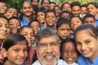 Selfie photo of Kailash Satyarthi and children laughing at the camera.