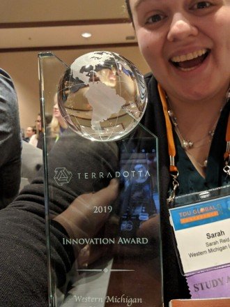 Sarah Reid smilely selfie, while holding her statue of appreciation recieved from Terra Dotta Innovation Award