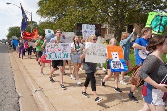 A group of people marches with signs about climate change.
