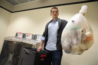 Turske holds a bag of trash.